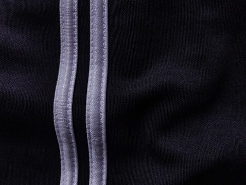Black sportswear fabric texture with white stripes detail closeup