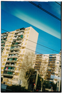 apartment blocks through a train window with reflections, 35mm film