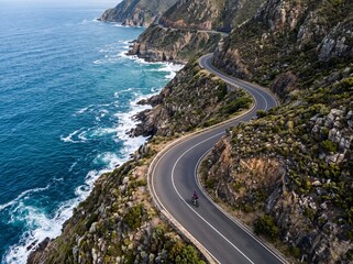 Obraz premium Aerial view of a winding coastal road along the rugged cliffs of South Africa.