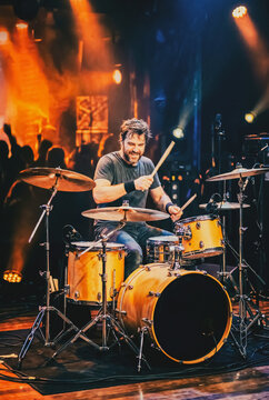 Batteur professionnel en concert live sous lumi&egrave;res color&eacute;es &ndash; performance musicale &eacute;nergique sur sc&egrave;ne