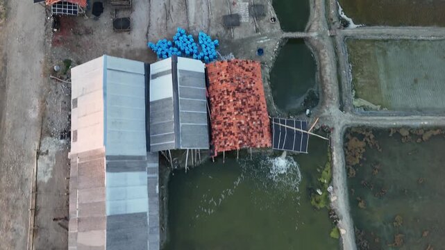 Top down aerial view of salt farm facility with and wooden huts