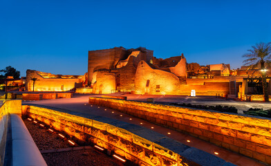 Fototapeta premium The illuminated mud brick ruins of At-Turaif World Heritage Site in Diriyah, Saudi Arabia, at dusk.
