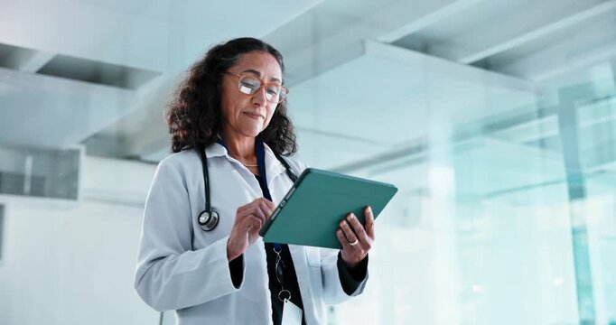 Doctor, writing and woman with tablet in clinic, research or treatment plan with information on web. Healthcare, medical professional and mature person with tech, scroll and health report in hospital