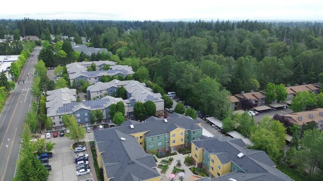 Solar panel installations align near Pete von Reichbauer Way S, covering multi family rooftops bordering timber stands, illustrating sustainable energy integration practices in Federal Way, WA