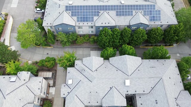Grey shingled roofs extend near Pete von Reichbauer Way South, where pitched architectural angles overlap lush deciduous trees and complex access lanes in Federal Way, Washington