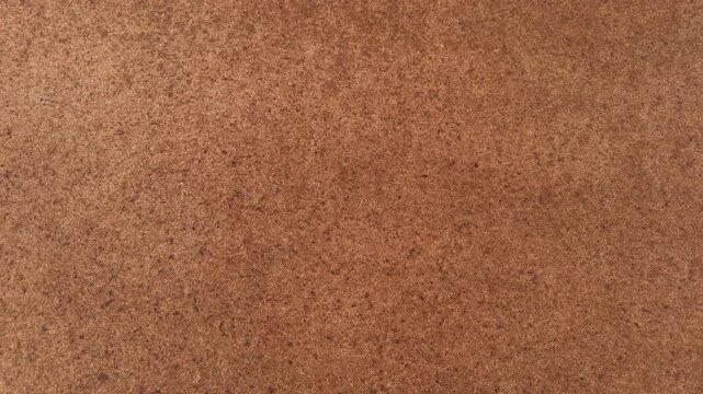Brown fabric texture with woven fibers and dark speckles, linen canvas background. Rustic textile backdrop, organic material, vintage pattern