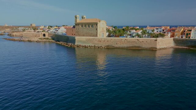 Aerial backwards shot of a speedboat navigating towards the beautiful historic fortified island of Tabarca, an islet located near the city of Alicante in Spain - stock video