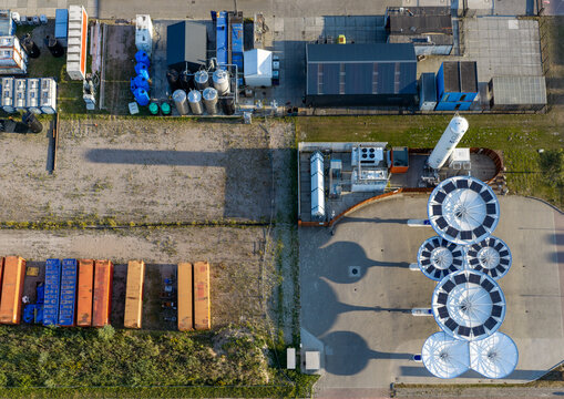 Aerial view of an energy hub featuring alternative fuel infrastructure, hydrogen storage tanks, and solar-like structures for green energy production in the Netherlands.