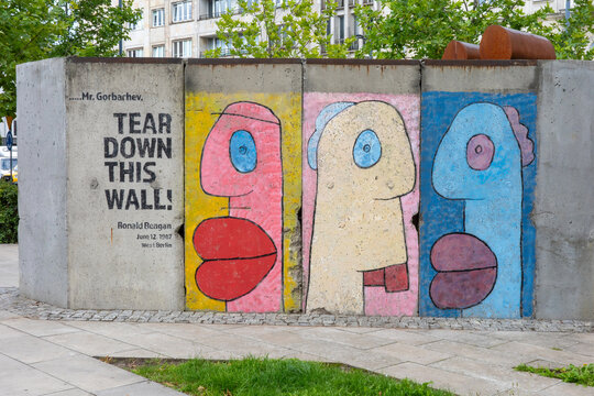 WARSAW, POLAND - JULY 24, 2026: A segment of the Berlin Wall with colorful pop-art figures and Ronald Reagan&rsquo;s iconic quote is displayed outdoors.