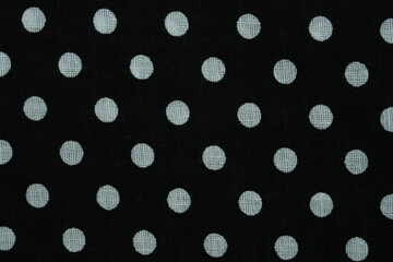 Black fabric displaying a white polka dot pattern, creating a classic textile background © Floren Horcajo
