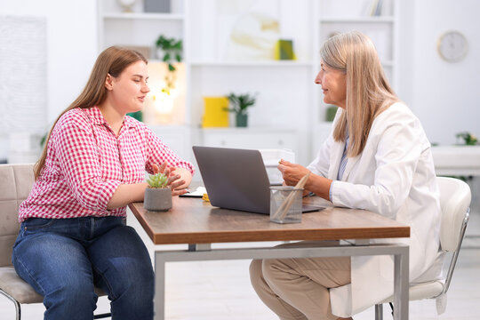 Weight loss. Nutritionist consulting overweight woman at wooden table in clinic