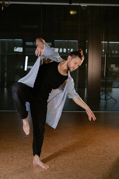 A man performs a randomized movement for yoga at a fitness gym
