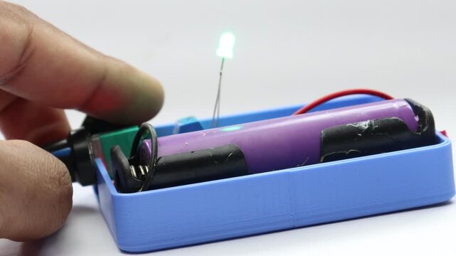 Green led bulb glowing and dimming powered by lithium-ion battery with voltage controller board