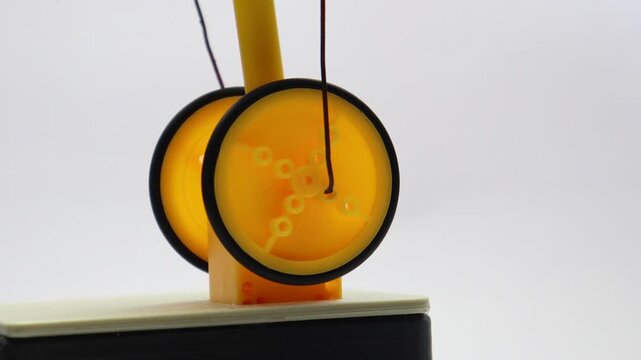 DC motor shaft connected to wheels and a steel wire converting one mechanical motion to another close up view