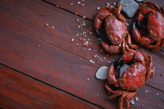 Cooked red crabs with sea salt on rustic wooden table, nutritious seafood rich in protein, healthy eating, balanced diet and natural food concept