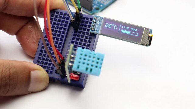Temperature and humidity sensor displaying readings on oled display connected to breadboard