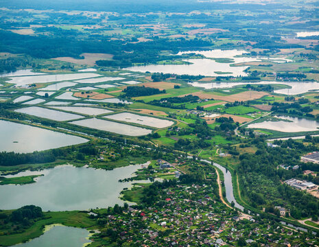 Aerial view of the landscape surrounding the town of Elektrenai, featuring interconnected lakes, agricultural fields, and residential areas in Elektrenai, Vilnius County, Lithuania.