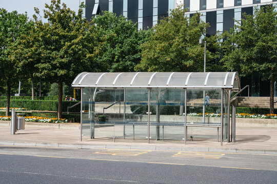 Corby, Northamptonshire, United Kingdom - July 15, 2026: Modern glass bus shelter in urban business district