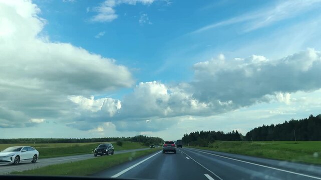 Minsk region Belarus July 7 2026 Highway drive with oncoming and passing traffic. Cars moving in both directions under a cloudy sky. Busy road trip scene captured during a countryside