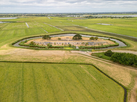 Aerial view of Fort at Krommeniedijk surrounded by a moat and lush green fields in Uitgeest, Noord-Holland, Netherlands.