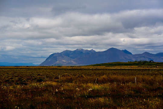 Panoramic view of volcanic mountain range over open tundra landscape in Iceland