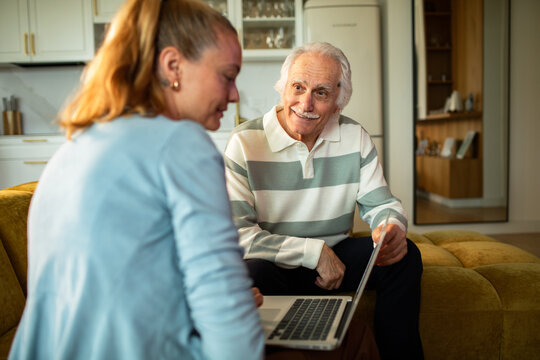 Senior man and woman using laptop at home