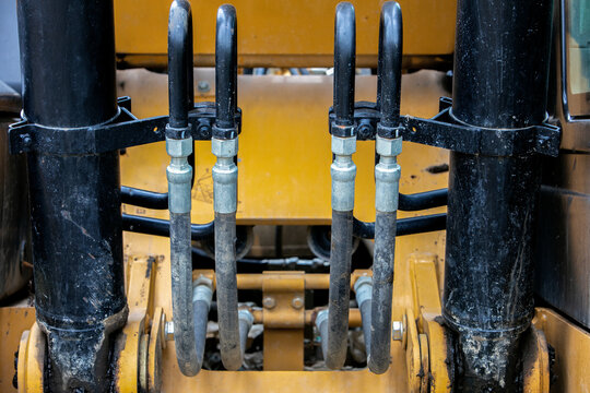 Closeup on hydraulic hoses and connectors on a backhoe