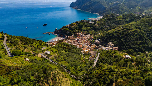 Aerial view of the colorful coastal village of Monterosso al Mare nestled among terraced hills and the blue Mediterranean Sea in Monterosso al Mare, Liguria, Italy.