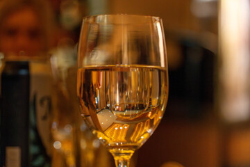Glass of White Wine on a Dark Restaurant Table © Jonathan
