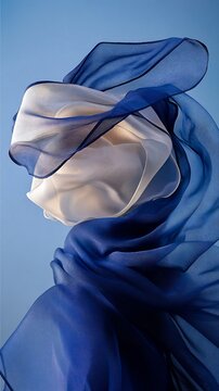 Fluid fabric drapes in a dynamic pose against a vibrant backdrop.  Soft, flowing fabrics in white and deep blue create a sense of movement and elegance
