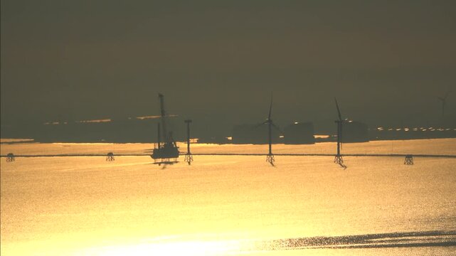 石狩湾新港沖の船体をジャッキアップした洋上風力発電の設置作業と石狩湾の朝
