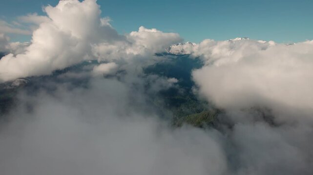 Cinematic drone flight rising above the clouds over the lush Caucasus Mountains in Svaneti, Georgia. Peaceful aerial landscape with breathtaking alpine peaks, ideal for travel, meditation and nature p