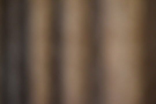 A dreamy view of a beige curtain hanging on the wall.