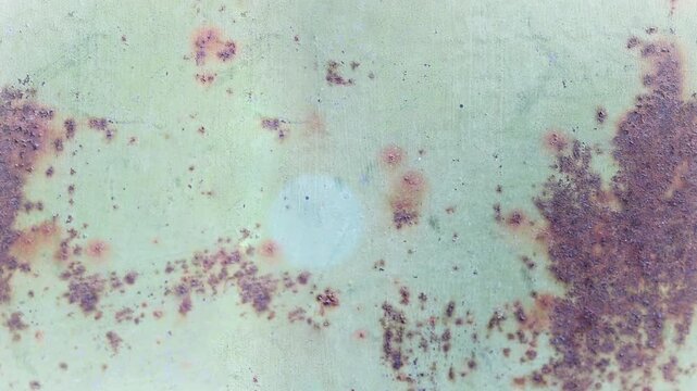 Seamless 4K looping vertical movement over a weathered green painted wall with purple stains and aged surface texture. Suitable for grunge backgrounds and artistic projects.