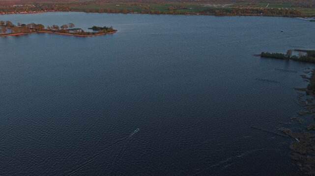 Aerial view of speedboat sailing on a dutch lake at sunset