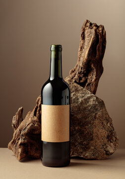 Red wine with old driftwood and a piece of granite rock on a beige background.