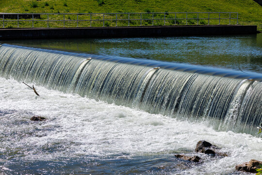 Water flowing over a weir creating white foam
