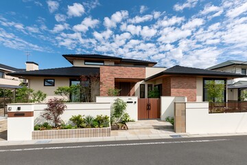 Fototapeta premium 晴れた青空の下に佇むモダンな新築一戸建てデザイン住宅の外観