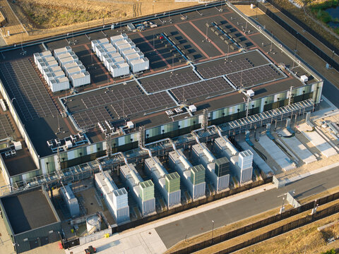 Aerial view of a hyperscale data center featuring rows of cooling units and industrial equipment on the roof during golden hour in Didcot, England, United Kingdom.