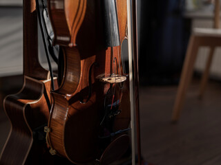 Close-up of violins hanging on a stand with their bows during a music recording. © Victor