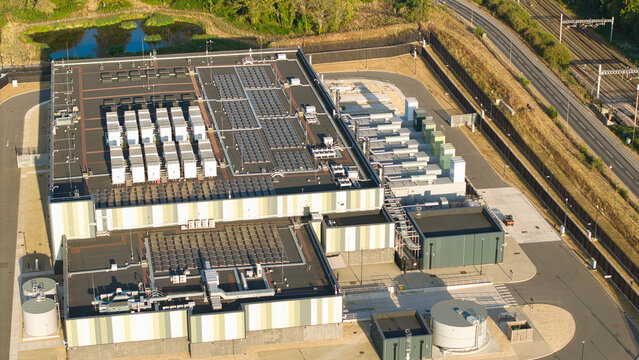 Aerial view of hyperscale data center with rooftop cooling units and hvac systems illuminated by golden hour light in Didcot, England, United Kingdom.