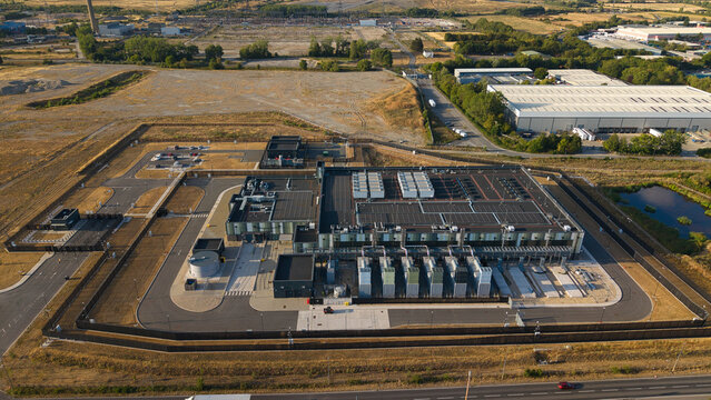 Aerial view of the Hyperscale Data Center during golden hour, featuring cooling units, parking areas, and surrounding industrial infrastructure in Didcot, England, United Kingdom.