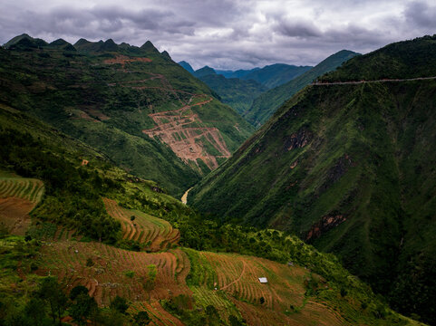 Aerial view of the Northernmost Point of Vietnam near the Chinese border, featuring mountain ranges, terraced fields, and a winding river valley in Lung Cu, Ha Giang, Vietnam.