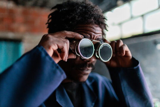 African worker wearing welding glasses preparing for work in a workshop