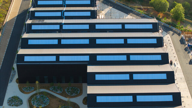 Aerial view of the modern solar roof of Tech Foundry 3 at Harwell Science and Innovation Campus, surrounded by landscaped grounds and access roads in Didcot, England, United Kingdom.