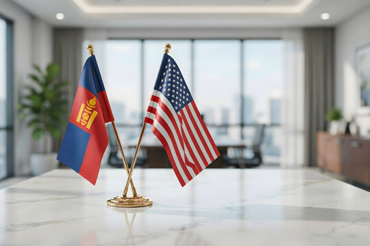 Desk flags of mongolia and the united states of america positioned on a white marble table inside a bright office with a blurred background