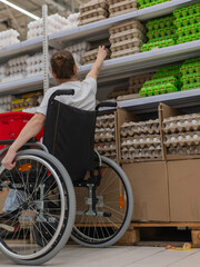 Obraz premium A Caucasian woman in a wheelchair shopping in a supermarket.