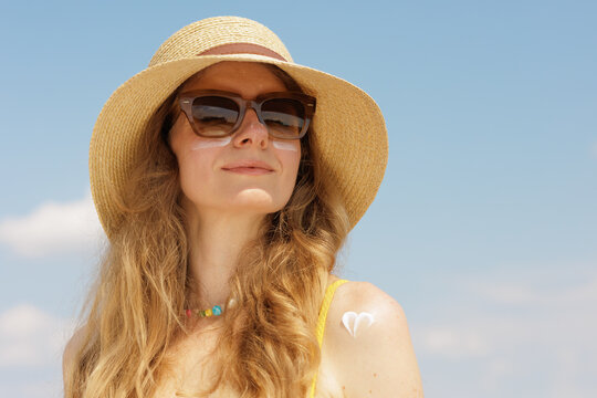 Woman Applying SPF Face Cream For Summer Sun Protection Outdoors