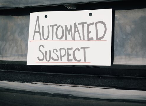 Man attaching protest license plates to vehicle using screwdriver, illustrating citizen pushback against ALPR surveillance - Fourth Amendment privacy