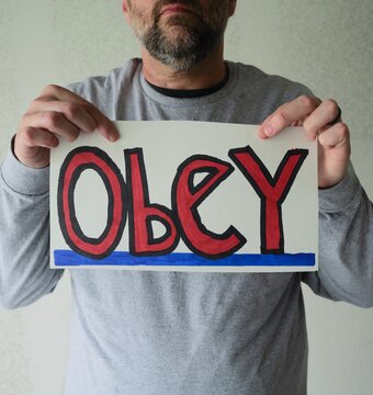 Man attaching protest license plates to vehicle using screwdriver, illustrating citizen pushback against ALPR surveillance - Fourth Amendment privacy